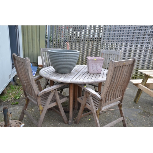 144 - Teak of set of four hairs and circular garden table. Diameter 125cm