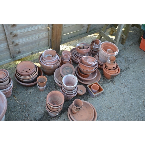 148b - Large quantity of mostly small terracotta planters and trays + plastic potting trays etc.