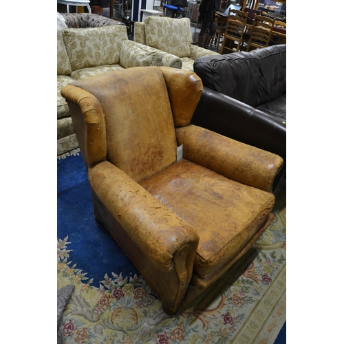 742 - Early C20 tan leather club chair with distressed leather