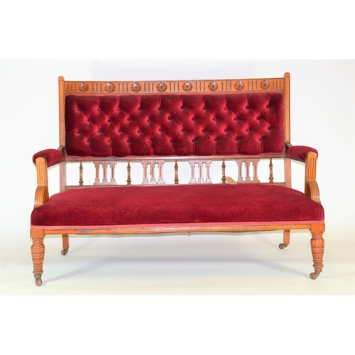 965 - Mahogany framed low sofa on castors, upholstered in a red velvet fabric, with button back detail. 13... 