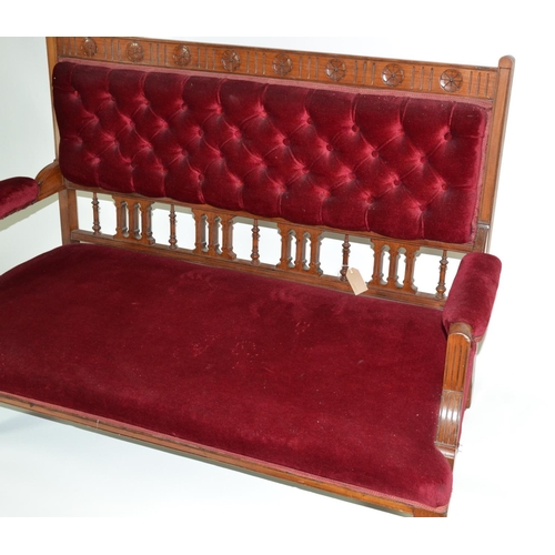 965 - Mahogany framed low sofa on castors, upholstered in a red velvet fabric, with button back detail. 13... 