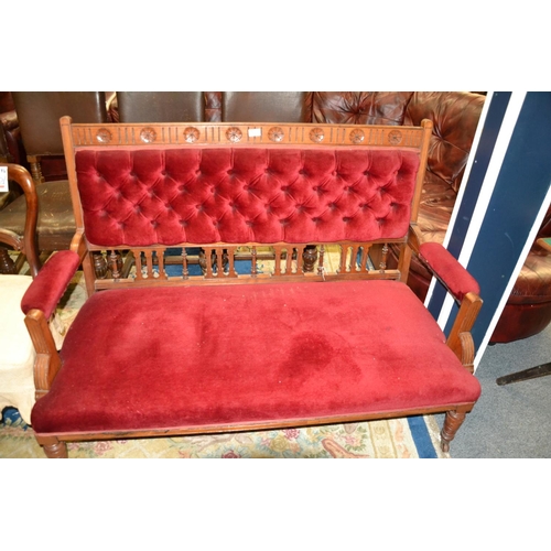 965 - Mahogany framed low sofa on castors, upholstered in a red velvet fabric, with button back detail. 13... 