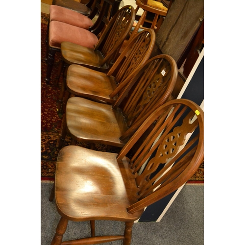 713 - Set of four wheel backed dining chairs