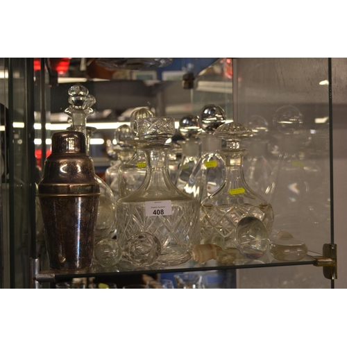 408 - Shelf of decanters, silver plated cocktail shaker and stoppers