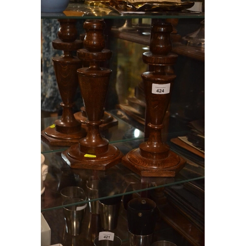 424 - Pair of turned oak candlesticks. h30c,