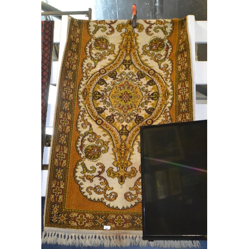 710 - Gold & yellow tone rug with central medallion, w91cm x 184cm