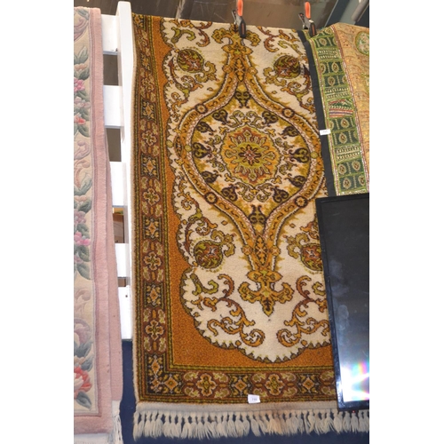 710 - Gold & yellow tone rug with central medallion, w91cm x 184cm