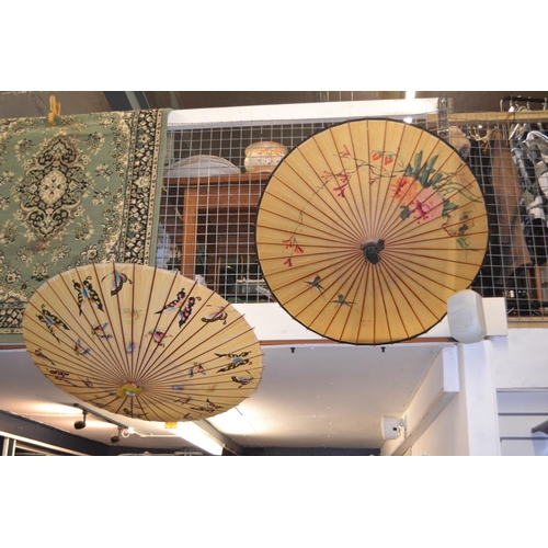 714 - Two hand painted Oriental parasols, one depicting butterflies, one with birds and flora