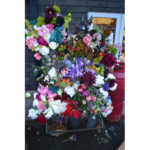 737 - Large quantity of silk flowers on rack including 8 buckets. (Rack not included).