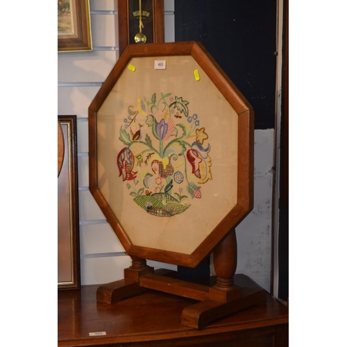 463 - Metamorphic octagonal fire screen with embroidered panel behind glass. 56cm wide x 68cm high 