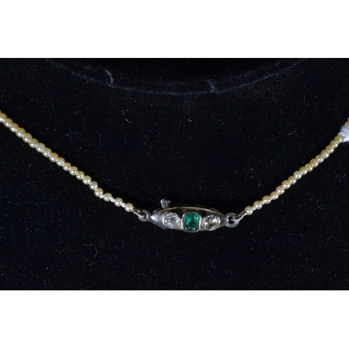 117 - Pearl necklace with white metal, diamond and emerald clasp, metal tests positive for 9ct gold, circu... 