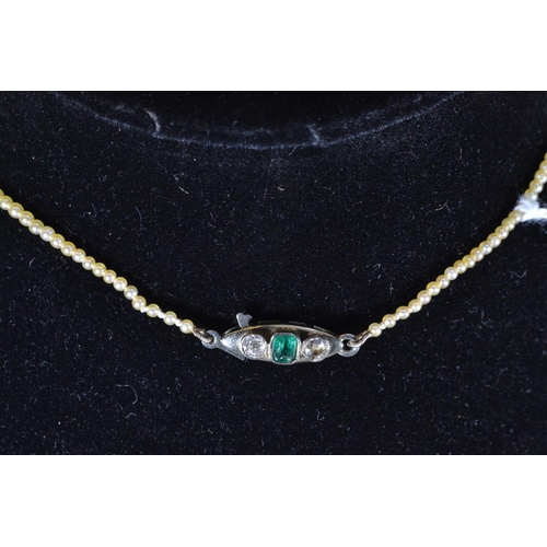 117 - Pearl necklace with white metal, diamond and emerald clasp, metal tests positive for 9ct gold, circu... 