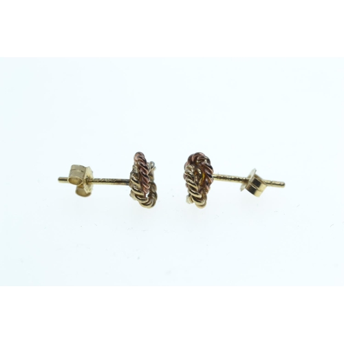 133 - Two pairs of 9ct gold ear studs, one set with topaz, the other designed as a tri-colour gold knot, g... 