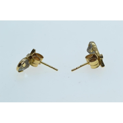 133 - Two pairs of 9ct gold ear studs, one set with topaz, the other designed as a tri-colour gold knot, g... 