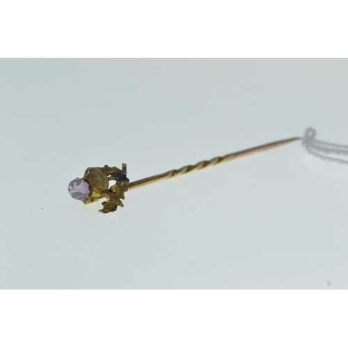 155 - 9ct gold twist thistle stick pin with amethyst coloured cut stone top, 1.1 gram