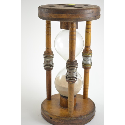 392 - Large hourglass, mounted in oak. 30cm high x 16cm diameter of top & base