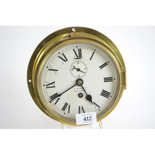 412 - Brass cased ships clock with key, F. Smith & Son Southampton. Diameter of face 18cm.