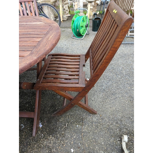 55 - Teak folding garden circular table with 4 folding chairs. Appears recently re-coated/varnished.