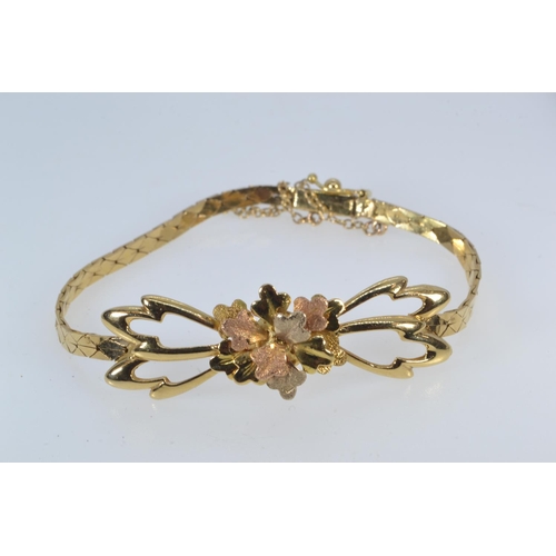 25 - Yellow metal tri-colour bracelet, with an open work floral design to the front, tested positive for ... 