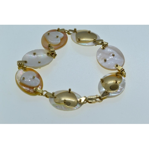 29 - 18ct gold & mother-of-pearl bracelet, each shell panel with a gold or shell heart motif, circumf... 