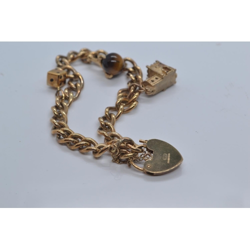 2 - 9ct gold charm bracelet with heart-shaped padlock clasp, with three charms, including church, di &am... 