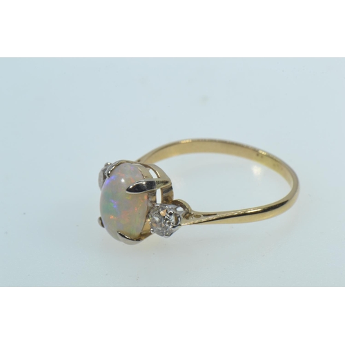 27 - 18ct gold ring with an oval cabochon opal in a yellow claw setting, flanked by round brilliant cut d... 