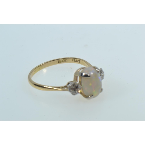 27 - 18ct gold ring with an oval cabochon opal in a yellow claw setting, flanked by round brilliant cut d... 