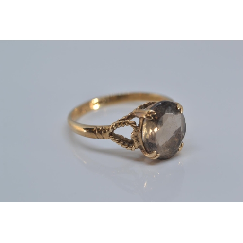 131 - 9ct gold ring claw-set with a smoky coloured stone, 9x8mm, size O/P, gross weight 2.2 grams