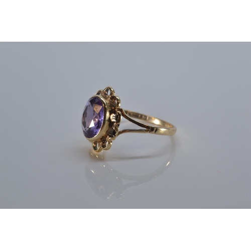 133 - 9ct gold ring bezel-set with a purple stone, size P, 3 grams