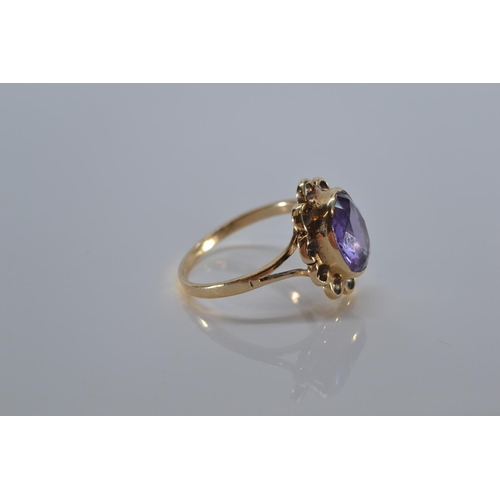 133 - 9ct gold ring bezel-set with a purple stone, size P, 3 grams