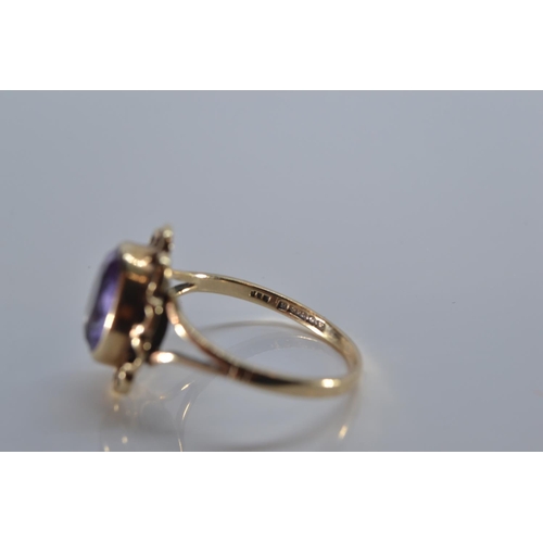 133 - 9ct gold ring bezel-set with a purple stone, size P, 3 grams