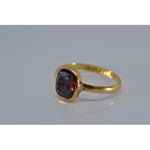 147 - 22ct gold ring with early Victorian hallmark, bezel-set with a red stone, size P, gross weight 2.1 g... 