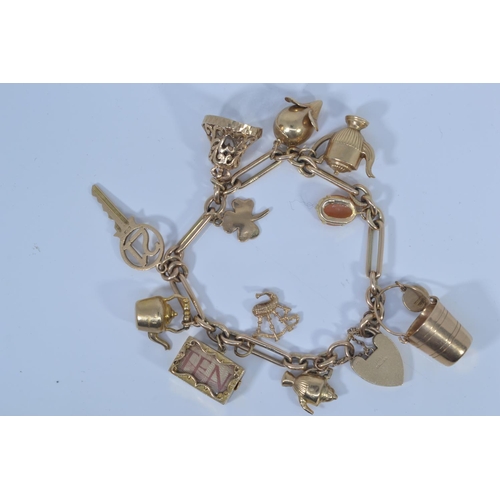 49 - 9ct gold charm bracelet with heart-shaped padlock clasp, suspending twelve 9ct gold charms, each lin... 