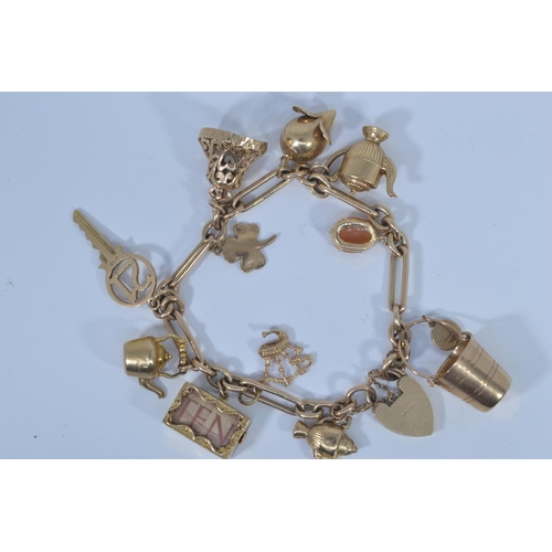 49 - 9ct gold charm bracelet with heart-shaped padlock clasp, suspending twelve 9ct gold charms, each lin... 