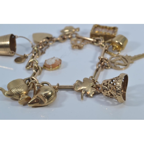 49 - 9ct gold charm bracelet with heart-shaped padlock clasp, suspending twelve 9ct gold charms, each lin... 