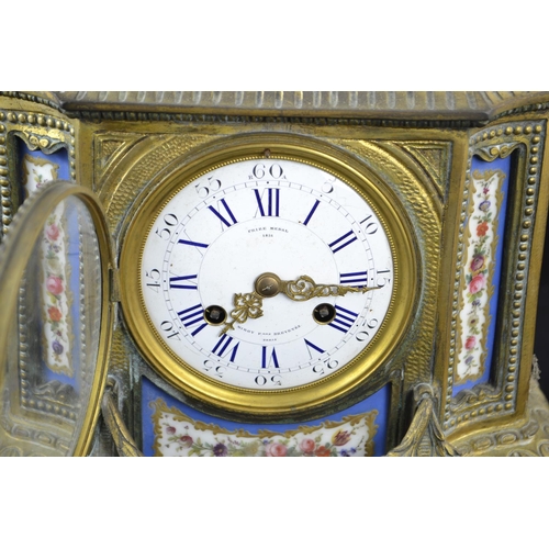 371 - Ornate French gilt and enamel mantle clock topped with a cherub and a ram, key present. Ht 41cms