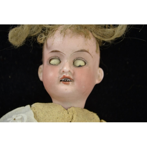 401 - Antique baby doll, head marked '390 A10/OM Made in Germany', length 23 cms, in wicker cradle