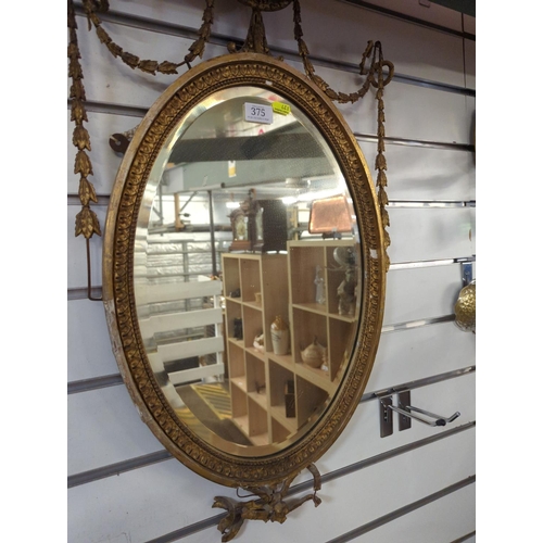 375 - Pair of oval bevelled gilt framed Empire style mirrors, overall W43x H73cm