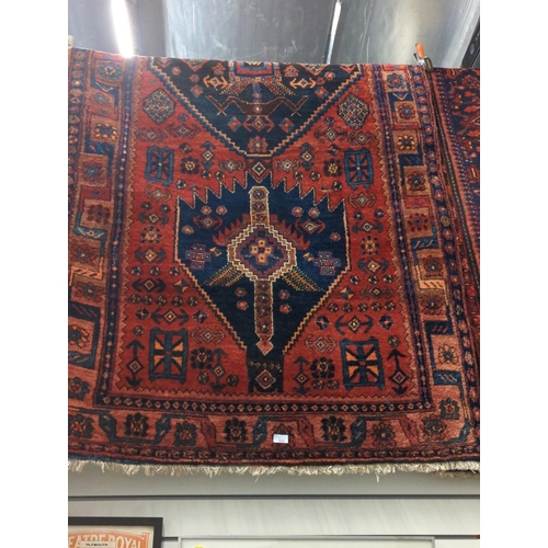 531 - Hand woven wool rug with red ground and navy & burnt orange geometric design. 120cm x 280cm