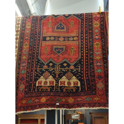 533 - Handmade wool rug. Red ground with geometric designs 255cm x 150cm