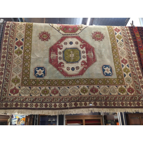 534 - Handmade wool rug. Cream ground with muted green blue & pink tones in a geometric design. 250cm ... 