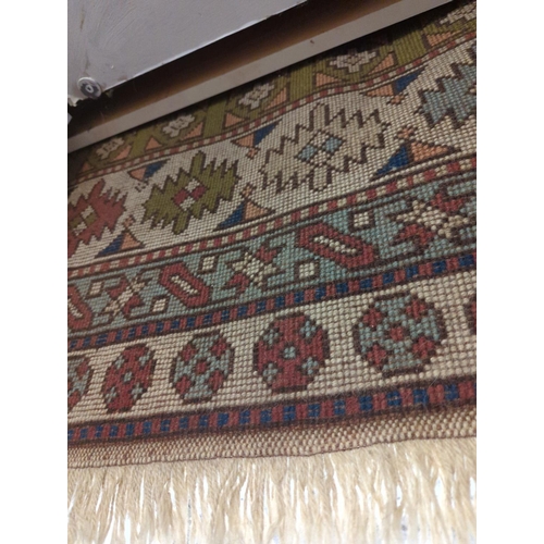 534 - Handmade wool rug. Cream ground with muted green blue & pink tones in a geometric design. 250cm ... 