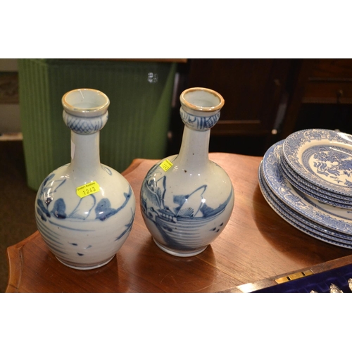 580 - Pair of blue and white vases with Oriental scenes. 22cm high