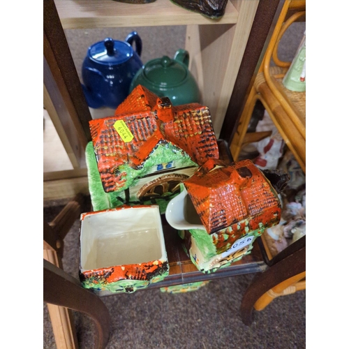 605D - English pottery four piece set of teapot, butter dish, cannister & sugar bowl modelled as cottag... 