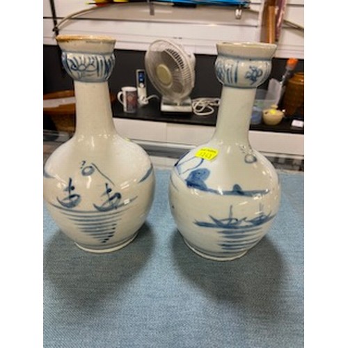 580 - Pair of blue and white vases with Oriental scenes. 22cm high