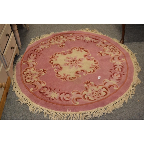 808 - Circular Chinese pink ground tasselled rug, diameter 130cm