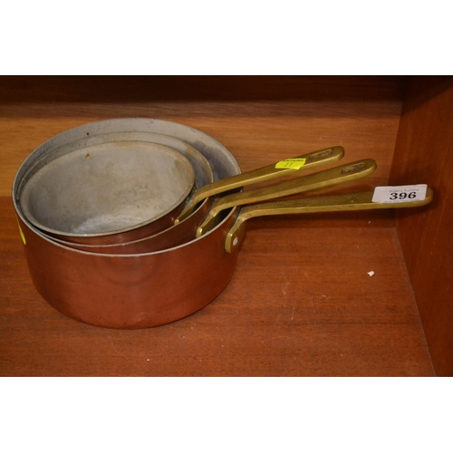 396 - Set of three graduated copper and brass saucepans