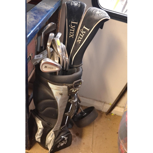 109 - Set of Lynx golf clubs, in bag with trolley