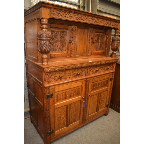 636 - Oak court cabinet, with carved details to front. 2 drawers & 4 cupboards. Includes key. W133cm D... 