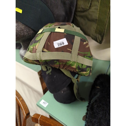 269 - Large quantity of assorted military clothing inc. flack jacket, four helmets, two hats and a wool gr... 